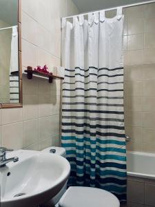 baño con lavabo y cortina de ducha en Boutique Hostal Lorca, en Nerja