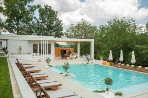 a swimming pool with lounge chairs and umbrellas at Apartmani Freedom place in Jagodina