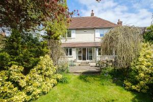 a white house with a garden in front of it at Turret House, Thorpeness - Close to the beach, Thorpeness Lake , Thorpeness Hotel, Golf and Country Club - Aldeburgh Coastal Cottages in Thorpeness