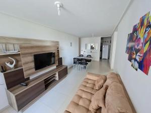 a living room with a couch and a flat screen tv at Anequim in Cabedelo
