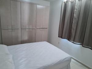 a bedroom with a white bed and a closet at Anequim in Cabedelo