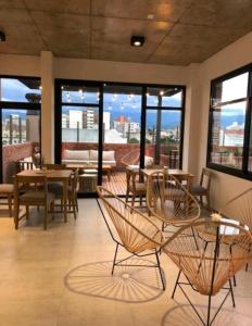 Una gran sala con mesas, sillas y ventanas. en Usina AS Salta, en Salta