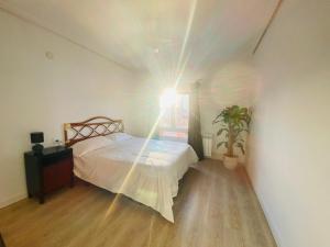 a bedroom with a bed with a light on the ceiling at Bonito Apartamento cerca del puerto de Castellón in Grao de Castellón