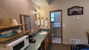 La salle de bains est pourvue d'un four micro-ondes et d'un lavabo. dans l'établissement Riverfront Motel & Cabins, à Thompson Falls