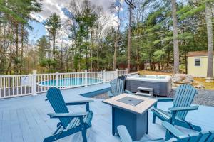 a patio with two chairs and a table and a tv at East Stroudsburg House with Hot Tub and Pool! in East Stroudsburg
