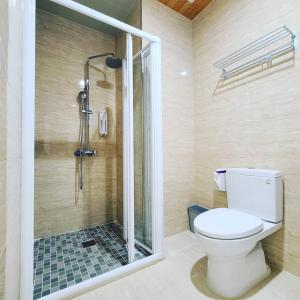 a bathroom with a toilet and a glass shower at Fay Homestay in Yilan City