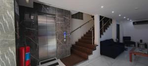 un vestíbulo con una escalera y una puerta con una maleta en La Cubana Hotel & Suites, en Colón
