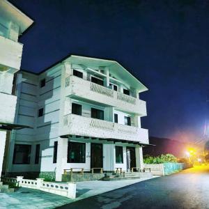 a large white building with balconies at night at Fay Homestay in Yilan City