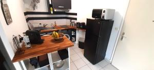 una pequeña cocina con encimera y nevera en Studio moderne, centre-ville, au calme, parking privé, en La Possession