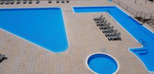 une vue aérienne d'une piscine avec un groupe de chaises et une piscine dans l'établissement Mar Azul, à Ericeira
