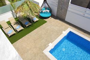 プロタラスにあるVilla Taliaの椅子2脚とハンモックが備わったプール