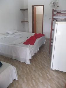 um quarto com uma cama com uma camisa vermelha em Pousada Edson em Caraguatatuba