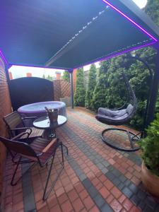 a patio with a blue canopy and a table and chairs at Apartament "Love Island" z Jacuzzi SPA dla Dwojga in Gniezno