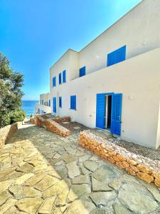 a building with blue doors and a stone walkway at Bilocale Vista Mare in Marettimo
