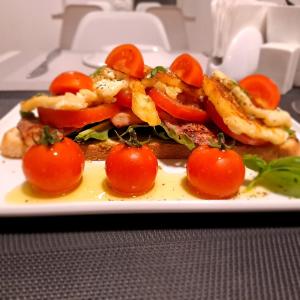 a plate of food with tomatoes on a table at La Veranda Hotel in Larnaca