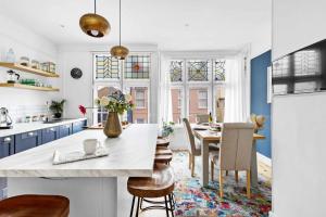 a kitchen with blue cabinets and a table with chairs at Flat 2 Fairfax Place - Modern stylish flat with plenty of charm in central Dartmouth in Dartmouth