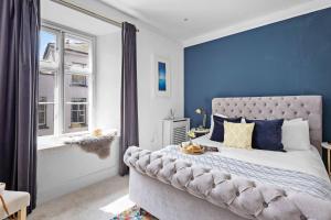 a bedroom with a large bed with blue walls at Flat 2 Fairfax Place - Modern stylish flat with plenty of charm in central Dartmouth in Dartmouth