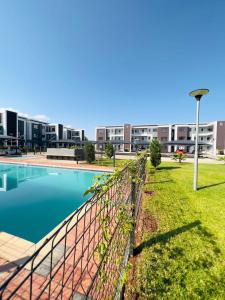 una valla junto a una piscina en un edificio en E105 Sarona City Flat E105, en Gaborone