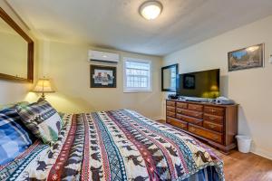 a bedroom with a bed with a dresser and a tv at Whittier Vacation Rental Cabin Pets Welcome! in Whittier