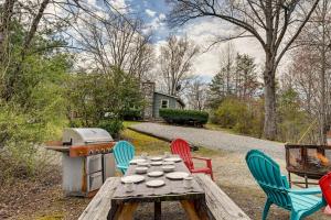a wooden table with four chairs and a grill at Whittier Vacation Rental Cabin Pets Welcome! in Whittier