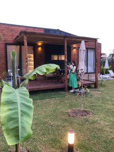 Eine Frau fotografiert ein Haus mit einer Pflanze. in der Unterkunft Lemon Tiny House in Antalya