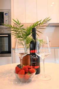 a bottle of wine and two glasses and strawberries on a table at Old Town Apartment in Omiš