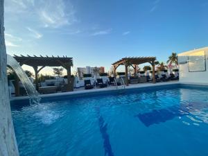 a swimming pool with a fountain in a hotel at Hotel Suites Mar Elena in Puerto Vallarta