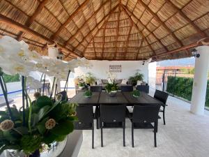 a dining table and chairs under a wooden roof at Hotel Suites Mar Elena in Puerto Vallarta