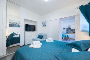 a bedroom with a blue bed and a chair at Harmony Apartments in Split