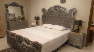 a bedroom with a large bed and two night stands at AQZ Three-bedroom apartment in Islamabad
