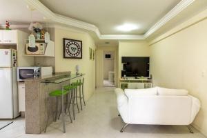 Una sala de estar con un sofá blanco y una cocina. en Frederico, en Meia Praia