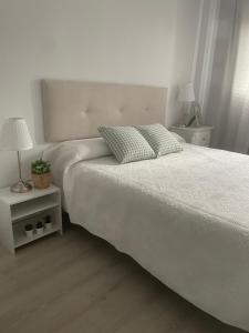 biała sypialnia z białym łóżkiem i lampką w obiekcie BAJO GUÍA DELUXE w mieście Sanlúcar de Barrameda +15 zdjęć