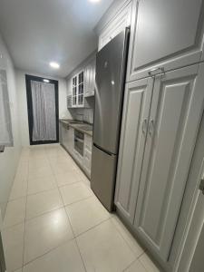 kuchnia z lodówką i podłogą wyłożoną kafelkami w obiekcie BAJO GUÍA DELUXE w mieście Sanlúcar de Barrameda
