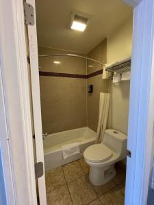 a bathroom with a toilet and a bath tub at La Casa Inn in Pasadena