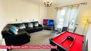 uma sala de estar com um sofá e uma mesa de bilhar vermelha em Two Bedroom Entire Flat, Luxury but Affordable Next to M90 em Fife