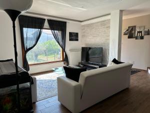 a living room with a white couch and a television at Villa MA-YA in Santa Maria Imbaro