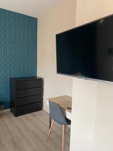 a room with a desk and a flat screen tv at Appart'Hôtel Sous Les Pins in Martigues