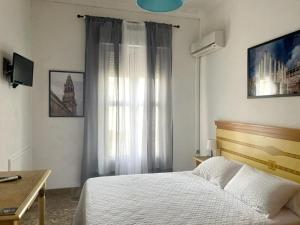 1 dormitorio con cama y ventana en Apartamento El Duque - Plaza de las Tendillas, en Córdoba