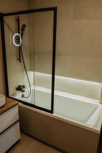 een douche in een badkamer met een glazen deur bij Soft Loft in Szczecinek