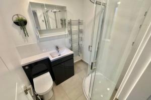 a bathroom with a shower and a toilet and a sink at Stadium View, 4 Bed 4 Ensuite Bathroom house in Huddersfield