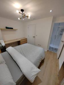 um quarto com 2 camas e um lustre em Stadium View, 4 Bed 4 Ensuite Bathroom house em Huddersfield