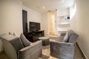 uma sala de estar com dois sofás e uma televisão em Entire 2 Bedroom Ground Floor Apartment - With Parking - Cardiff City Centre em Cardiff