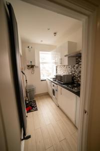 uma cozinha com um lavatório e um fogão forno superior em Entire 2 Bedroom Ground Floor Apartment - With Parking - Cardiff City Centre em Cardiff