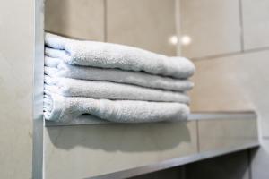 a stack of towels sitting on a counter in a bathroom at Entire 2 Bedroom Ground Floor Apartment Cardiff City Centre & Stadium in Cardiff