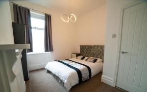 um quarto com uma cama e uma janela em Entire 2 Bedroom Ground Floor Apartment - With Parking - Cardiff City Centre em Cardiff