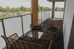 een balkon met stoelen en uitzicht op het water bij Soft Loft in Szczecinek