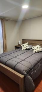 een slaapkamer met een bed met 2 kussens erop bij Cómoda y Acogedora casa climatizada in Punta Arenas