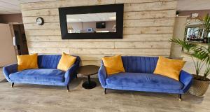 two blue chairs in a lobby with a mirror at Best Western Terre de Provence in Le Cannet-des-Maures