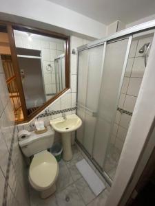 a bathroom with a toilet and a sink and a shower at Inka House Hotel in Machu Picchu