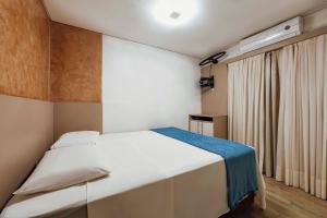 伊塔佩馬的住宿－Tropical Itapema，卧室配有白色的床和窗户。